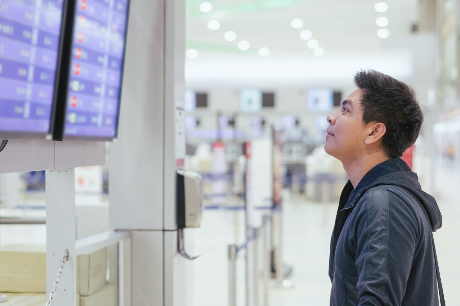 Young asian Passanger at the self-service check-in machine in departure hall at  airport.