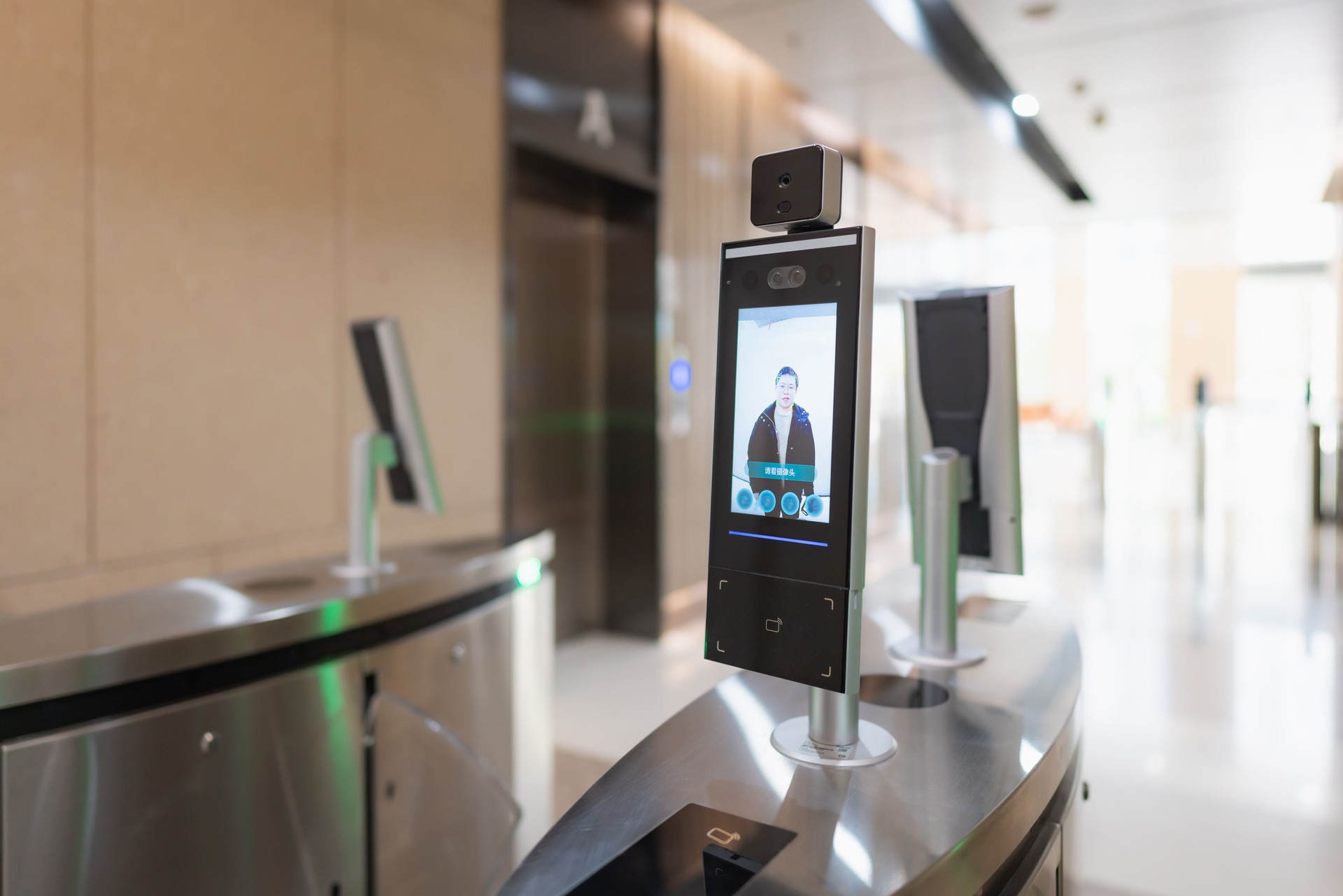 Close-up of a man using facial recognition technology to unlock a gate