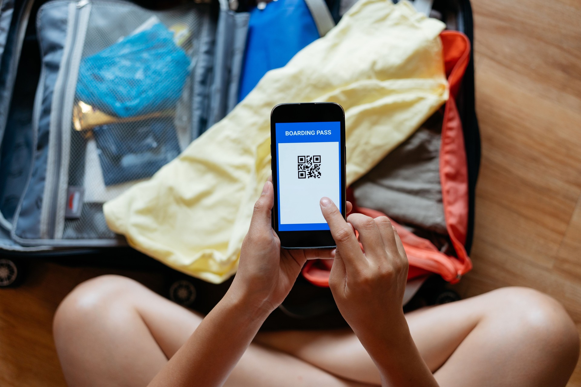 Young woman checking electronic boarding pass on smartphone